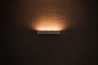 A wall sconce mounted at eye level casting a soft glow on the wall