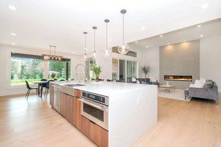A modern kitchen lit with layered ambient, task and island pendant lighting