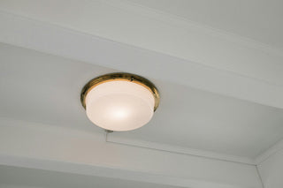 White ceiling light fixture with a brass trim