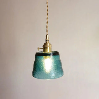 Pendant with cup-design glass shade over dining area