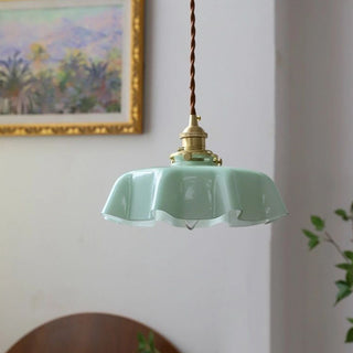 Glass ribbon pendant lamp over round dining table