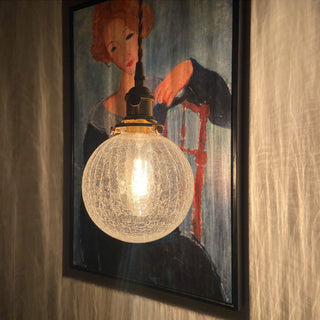Glass globe pendant close-up — black gold finish hanging lamp