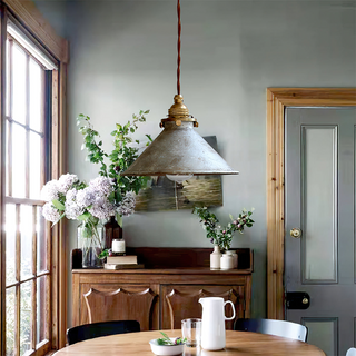 Industrial brass pendant over dining room table