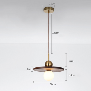 Walnut pendant with globe-shaped brass accent over dining table