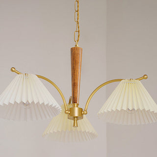 Pleated brass chandelier illuminated — elegant dining wood warm