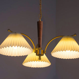 Elegant pleated chandelier close-up — brass wood dining detail