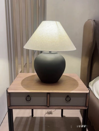 Matte black ceramic lamp side — rounded silhouette detail