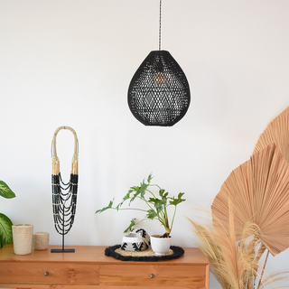 Black rattan wicker pendant casting warm boho glow