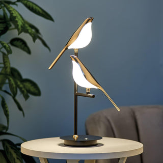 Modern golden bird lamp illuminated — touch warm ambient