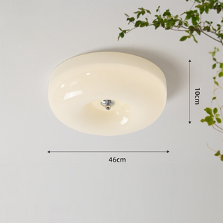 Round cream ceiling fixture in cozy bedroom, soft ambient glow