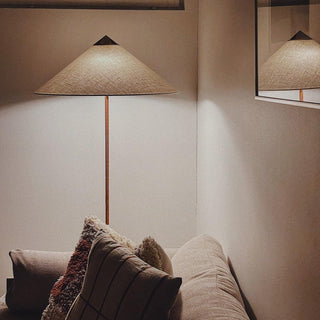 Tall rattan lamp illuminated — vintage woven shade warm