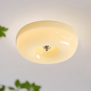 Round cream glass flush mount ceiling light in bedroom, warm soft glow
