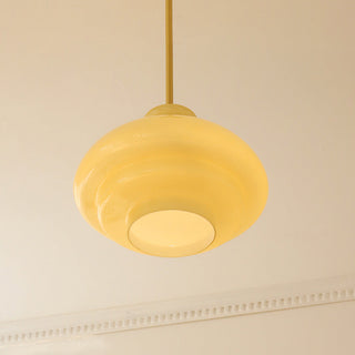 Three-layer yellow glass pendant hanging in dining room interior