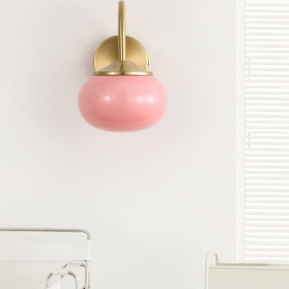 Pink glass bedroom wall sconce gold detail — modern
