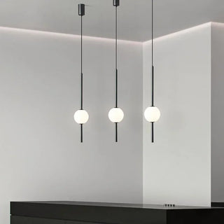 Contemporary black glass pendant hanging in a modern dining room