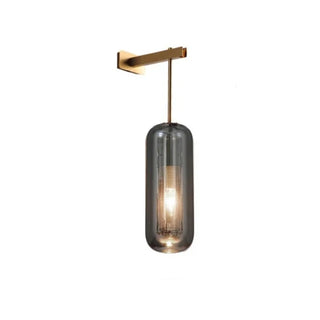 Brass wall sconce with smoke glass shade illuminated — Nora wall lamp
