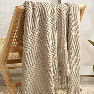 hand-knitted blanket cozy knit cream brown textured throw close-up
