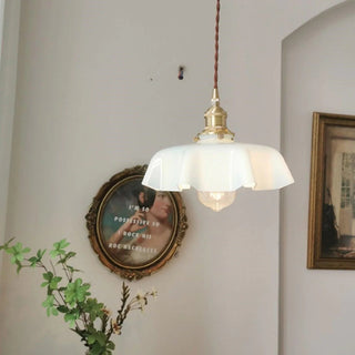 Glass pendant with ribbon-edge shade casting soft warm glow