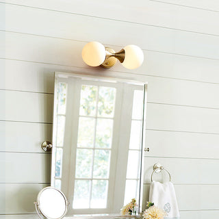 Brass double head vanity wall lamp illuminated — gold bathroom