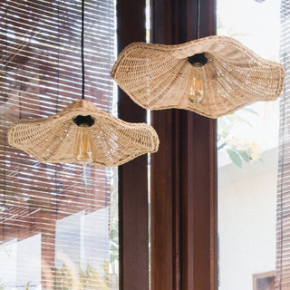Handwoven rattan pendant casting dappled light — dining room