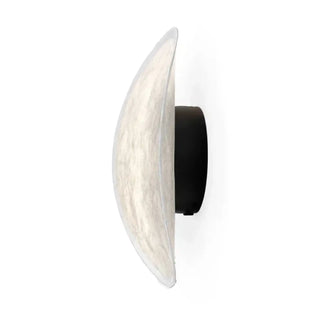 White half moon wall sconce installed in serene bedroom