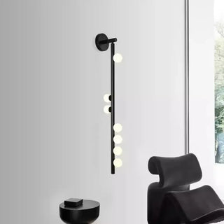 Slender gold wall sconce with frosted diffuser – installed bedroom