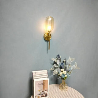 Minimalist gold glass wall sconce close-up brass stem