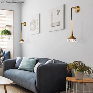 Gold brass wall sconce installed in contemporary living room