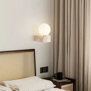 White glass ball wall sconce mounted on natural stone – 3000K warm glow