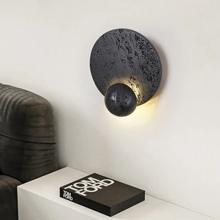 Volcanic stone wall light close-up – black round textured rock surface
