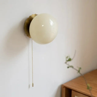 Sally round frosted glass wall sconce installed – warm glow