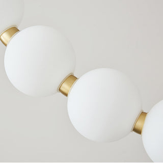 Pearl ball LED chandelier setting — modern brass acrylic wide