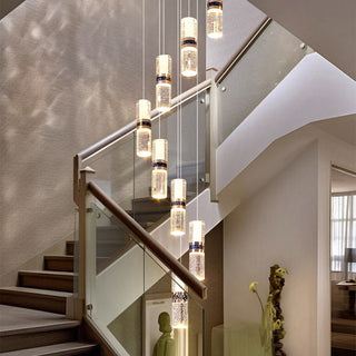 Long cascade crystal chandelier ambient — luxury staircase warm glow
