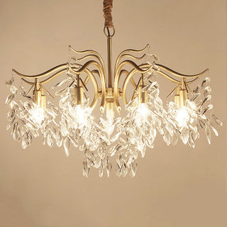 Large gold crystal chandelier illuminated — tiered dining warm