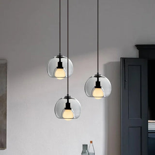 Orb glass pendant lamp casting warm amber light