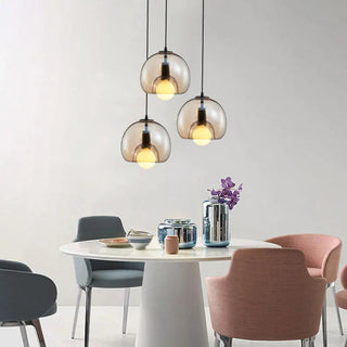 Handblown glass pendant with amber orb over dining table