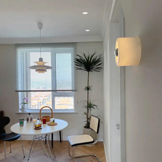 White circular glass wall sconce – minimal hallway side angle