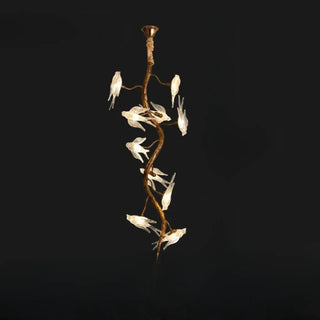 Decorative bird branch pendant over dining table — gold statement lamp