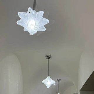 Designer star pendant lamp close-up, elegant glass ceiling fixture with warm ambient glow