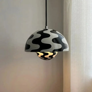 Black white patterned pendant light illuminated — bold designer ceiling lamp