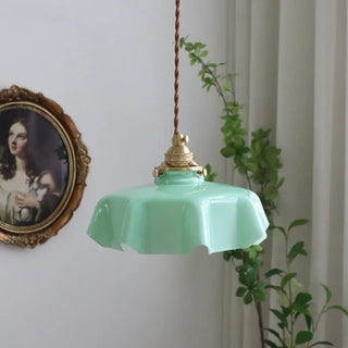 Retro wavy pink glass pendant lamp close-up, aged brass hanging ceiling fixture